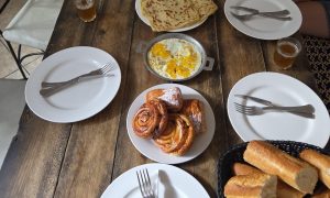 Breakfast at Nomad Surf Camp with croissant, baguette, omelette, msemen, and Moroccan tea in Tamraght