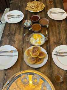 Traditional Moroccan breakfast with amlou, harcha, eggs, msemen, and jam served at Nomad Surf Camp in Tamraght, Morocco